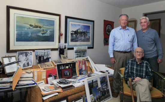 In this Dec. 1, 2011 photo, Maj. Thomas Griffin, seated, poses next to a couch covered with memorabilia from World War II at his home in Cincinnati with Ray Hughes, left, a veteran of the Strategic Air Command, and fellow WW II veteran Bill Barr. Griffin was a navigator on one of the planes used in Doolittle's raid on Japan in 1942. Coming just four months after the Imperial Japanese Navy savaged the U.S. Pacific Fleet at Pearl Harbor, the Doolittle raid on Japan's home did little damage, but lifted the spirits of Americans and electrified a world at war. (AP Photo/Al Behrman) 
