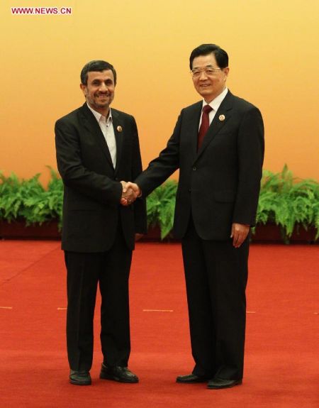 Chinese President Hu Jintao (R) shakes hands with Iranian President Mahmoud Ahmadinejad prior to the large group meeting of the 12th Meeting of the Council of Heads of Member States of the Shanghai Cooperation Organization (SCO) at the Great Hall of the People in Beijing, capital of China, June 7, 2012. (Xinhua/Lan Hongguang) 