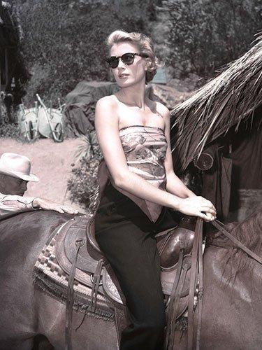 Grace Kelly riding a horse on set, c. 1953 Kelly's outfit equation couldn't be simpler: Sunglasses + scarf as top + black pants = relaxed glamour. (photo/Agencies)