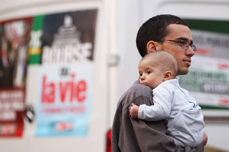 A man and his child attend a protest in Cannes